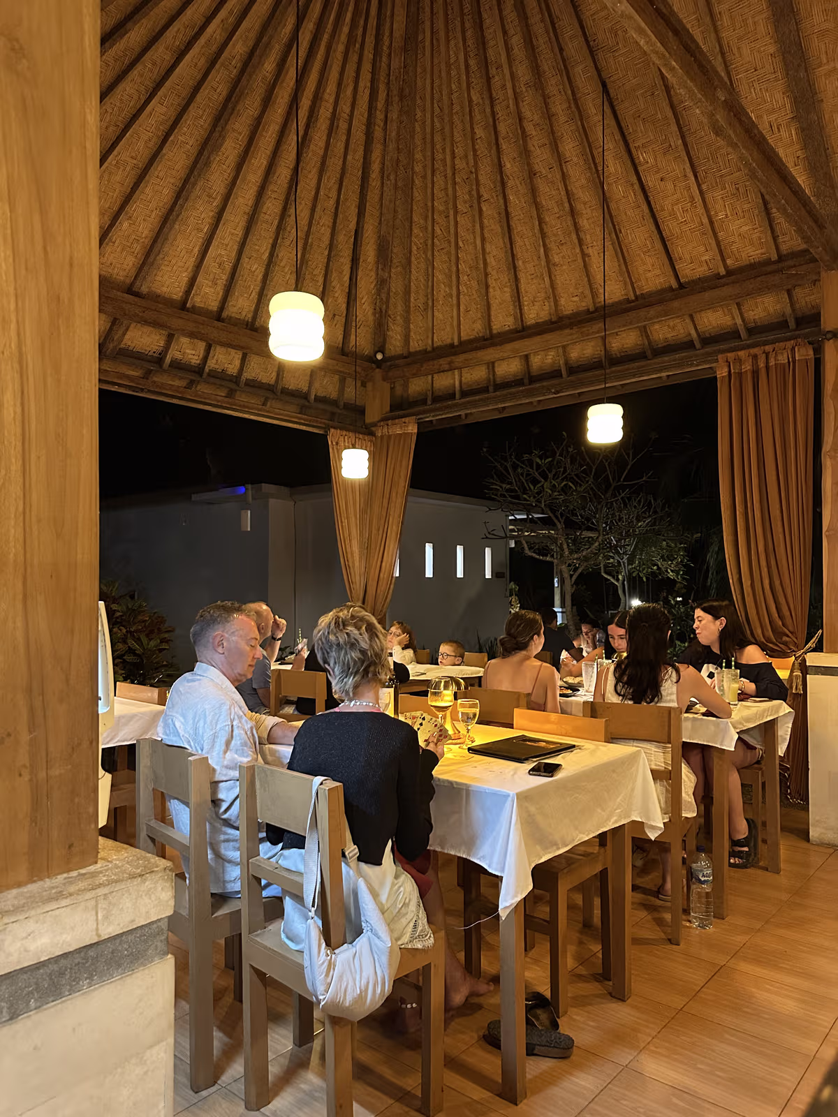 Evening guests dining under the timber pavilion